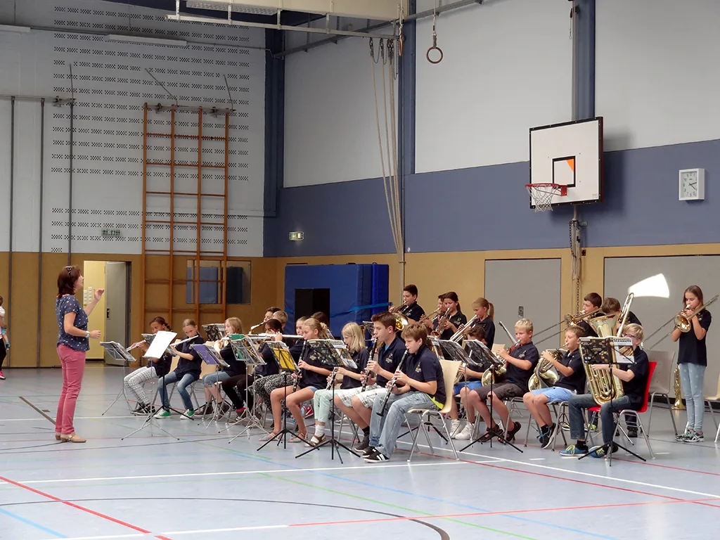 Schulorchester spielt am Rand der Sporthalle.